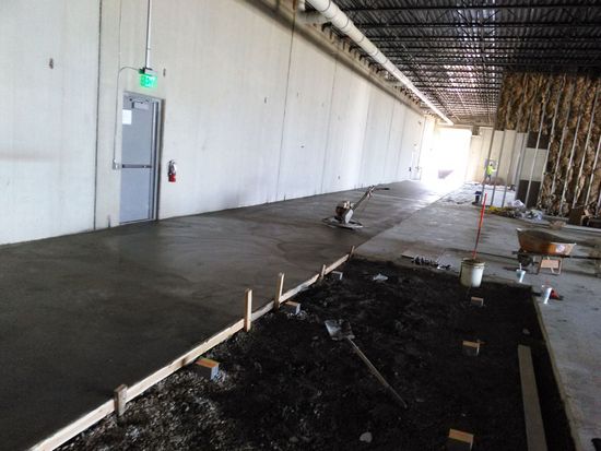 A building under construction with a green exit sign on the wall