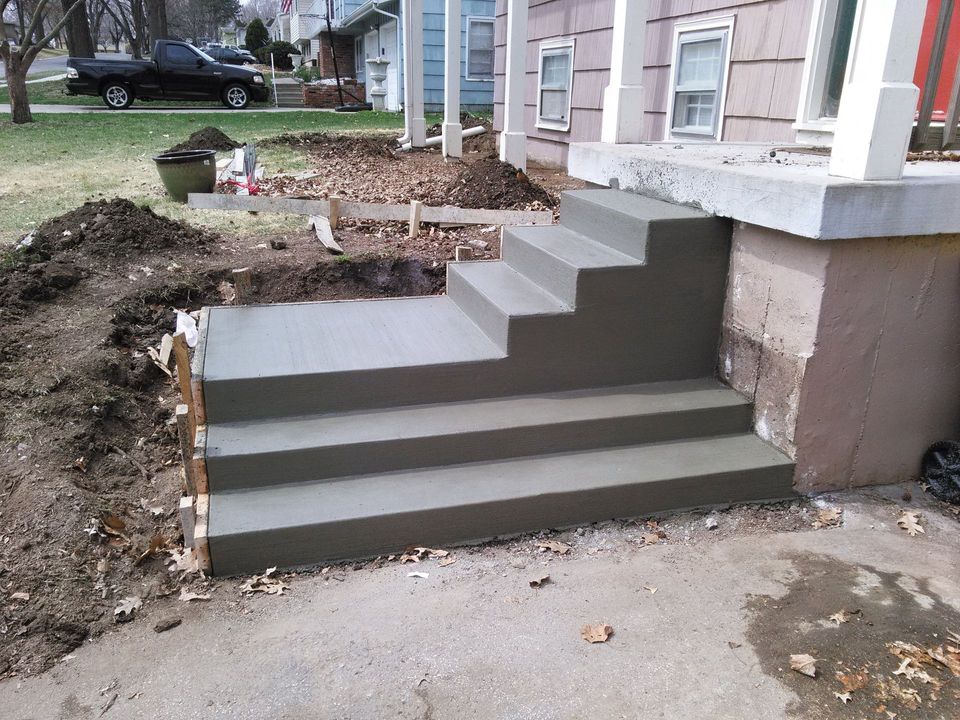 A set of concrete steps being built in front of a house