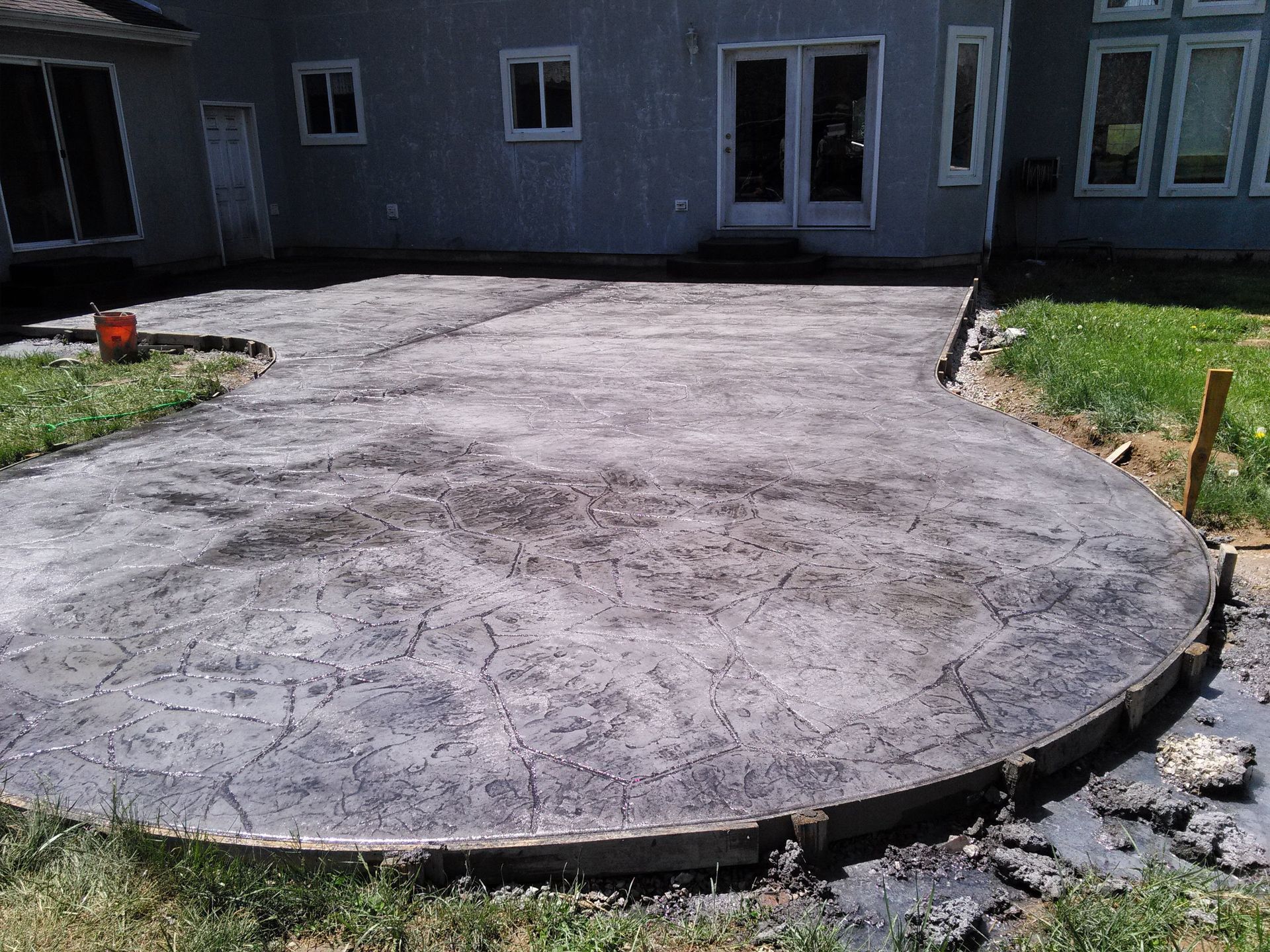 A concrete patio is being built in front of a house
