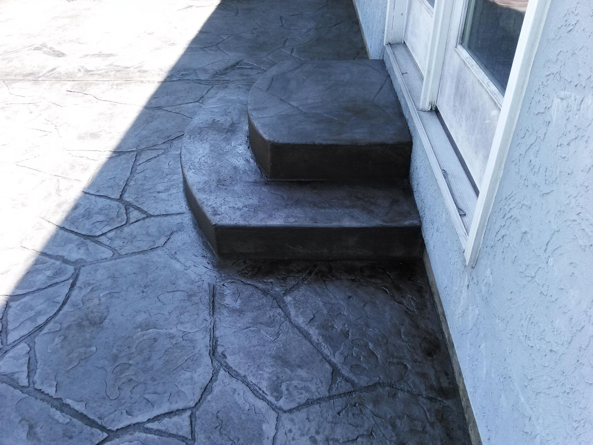 A concrete walkway with steps leading up to a door