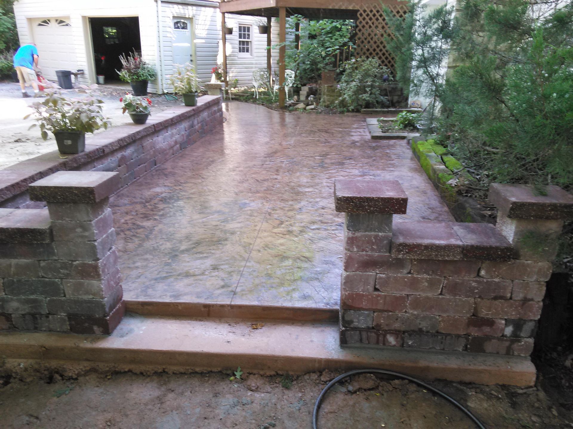 A patio with a brick wall and steps leading to it