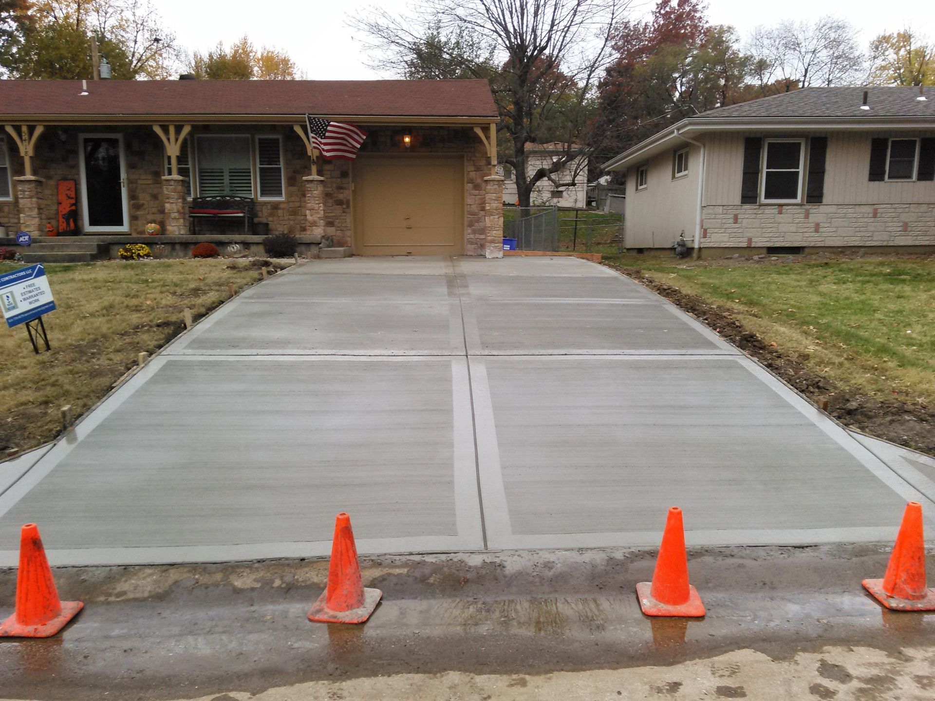A concrete driveway is being built in front of a house.