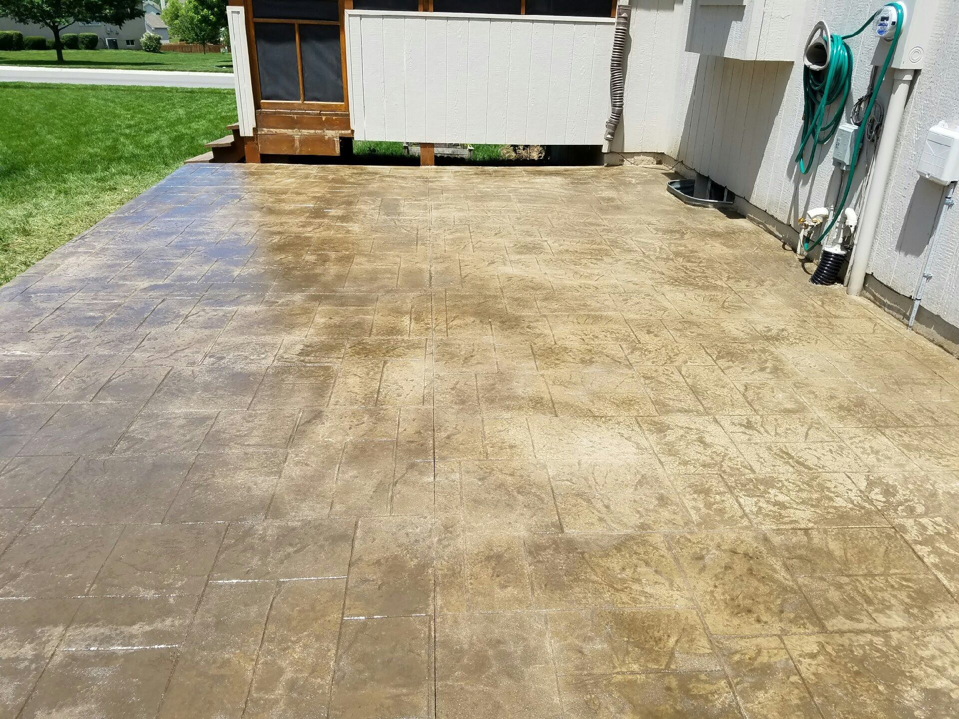 A patio with a hose attached to the side of it