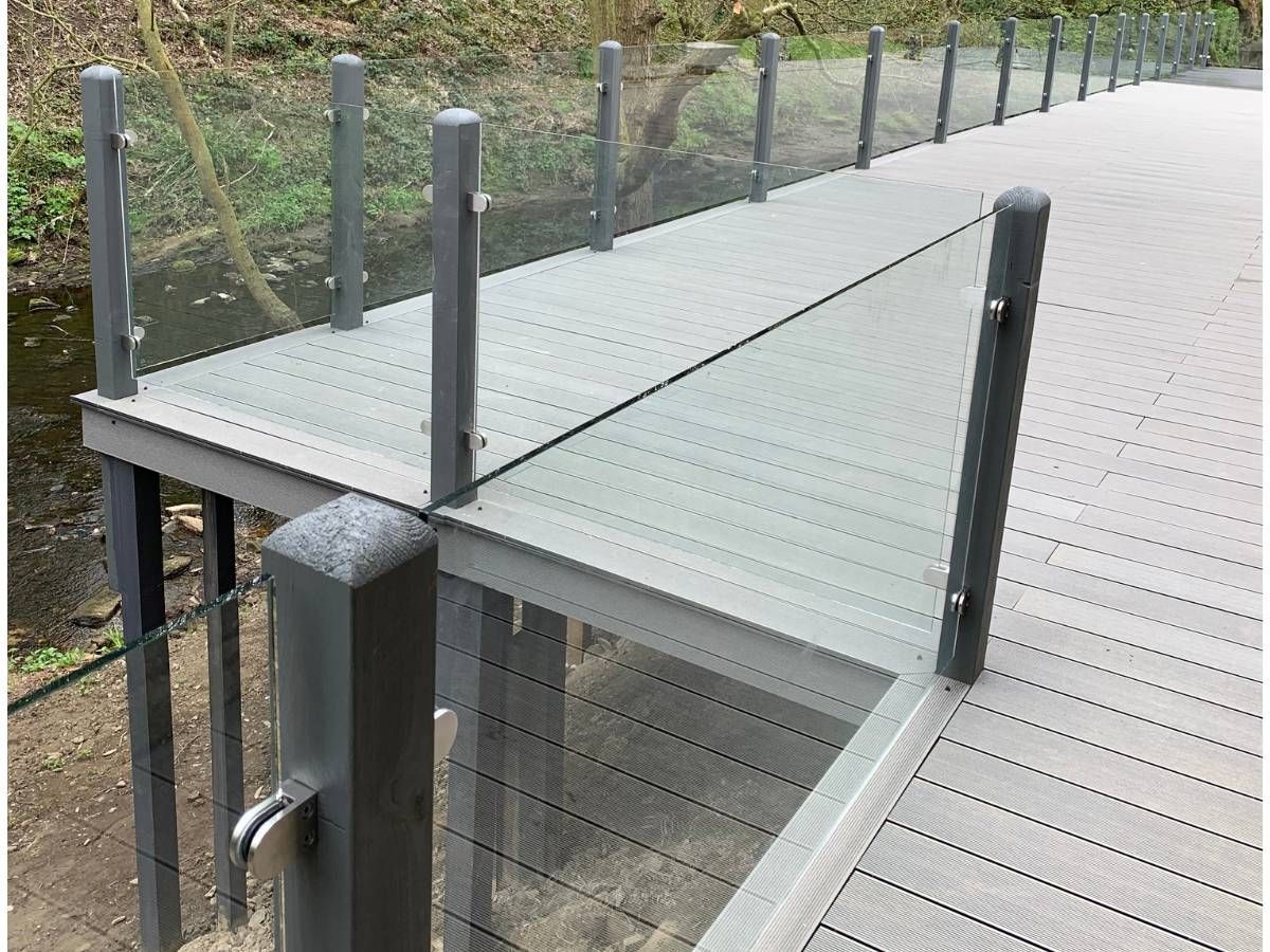 Composite Gates UK Light grey raised composite decking with glass balustrade