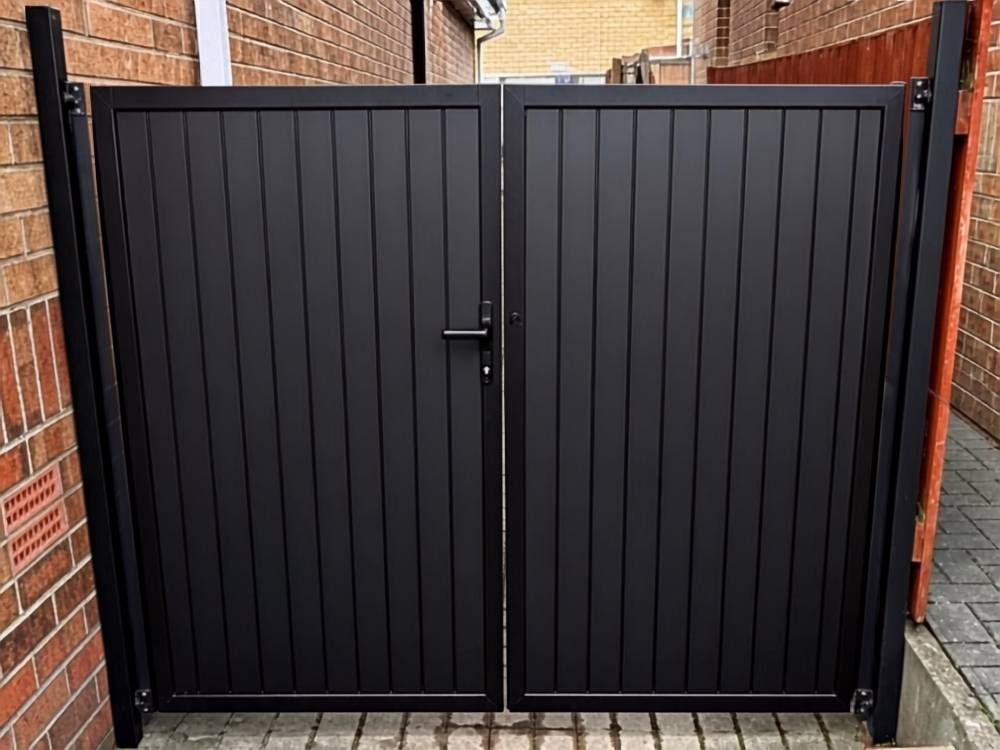 Anthracite grey composite double driveway gates hung between brick piers