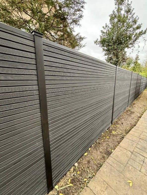 Composite Gates UK light grey composite fencing installed on a brick wall between brick pillars in Derby