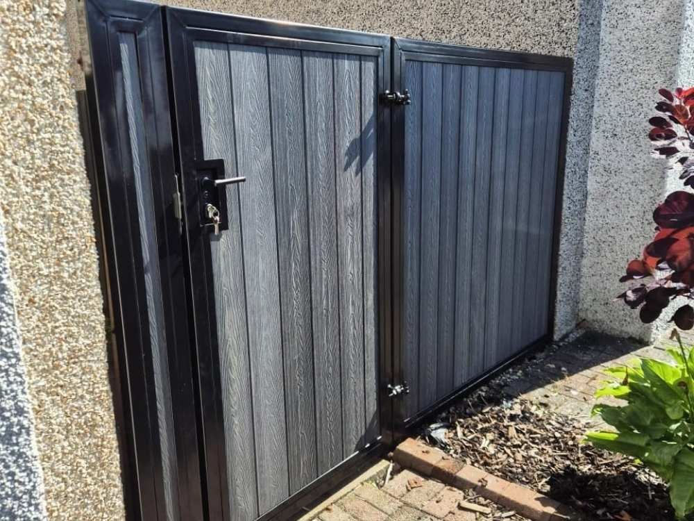 Anthracite grey composite side gates and a matching pedestrian gate with a lever handle and lock