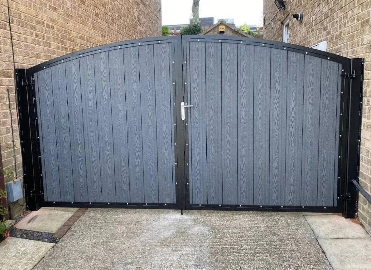 Hinged grey arched composite driveway gates in South London