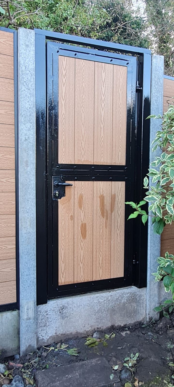 Composite Gates UK raised light oak garden gate fitted between composite fencing