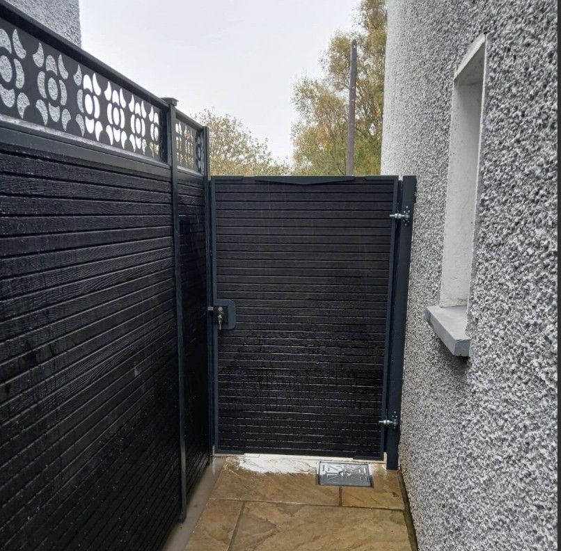 Anthracite grey composite garden gate alongside anthracite grey composite fence with trellis