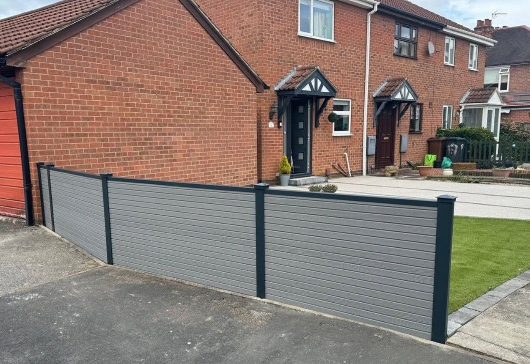 Composite Gates UK natural timber composite fencing installed in a sloping garden in Peterborough