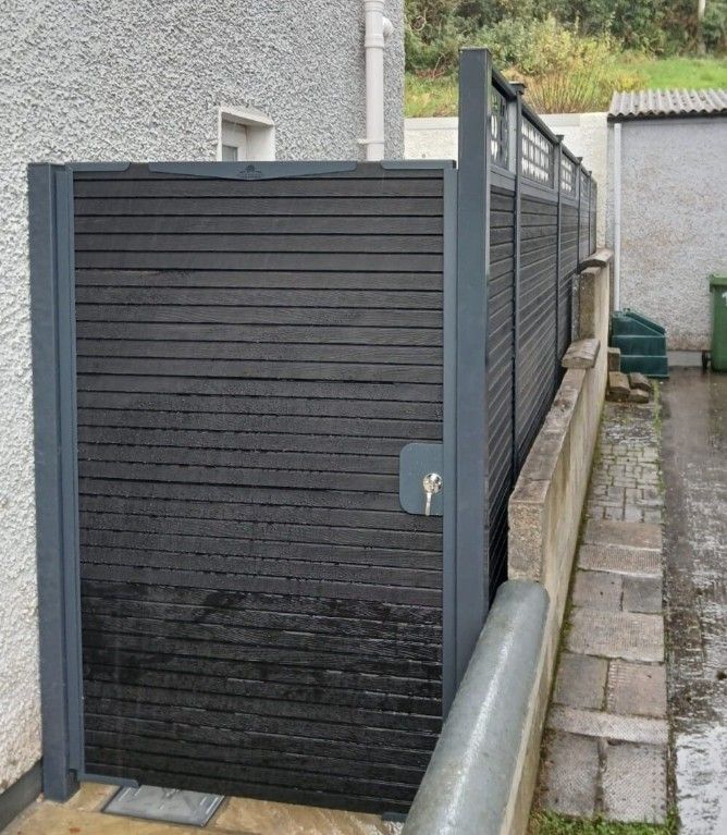 Dark composite garden gate with horizontal boards beside matching fence panels