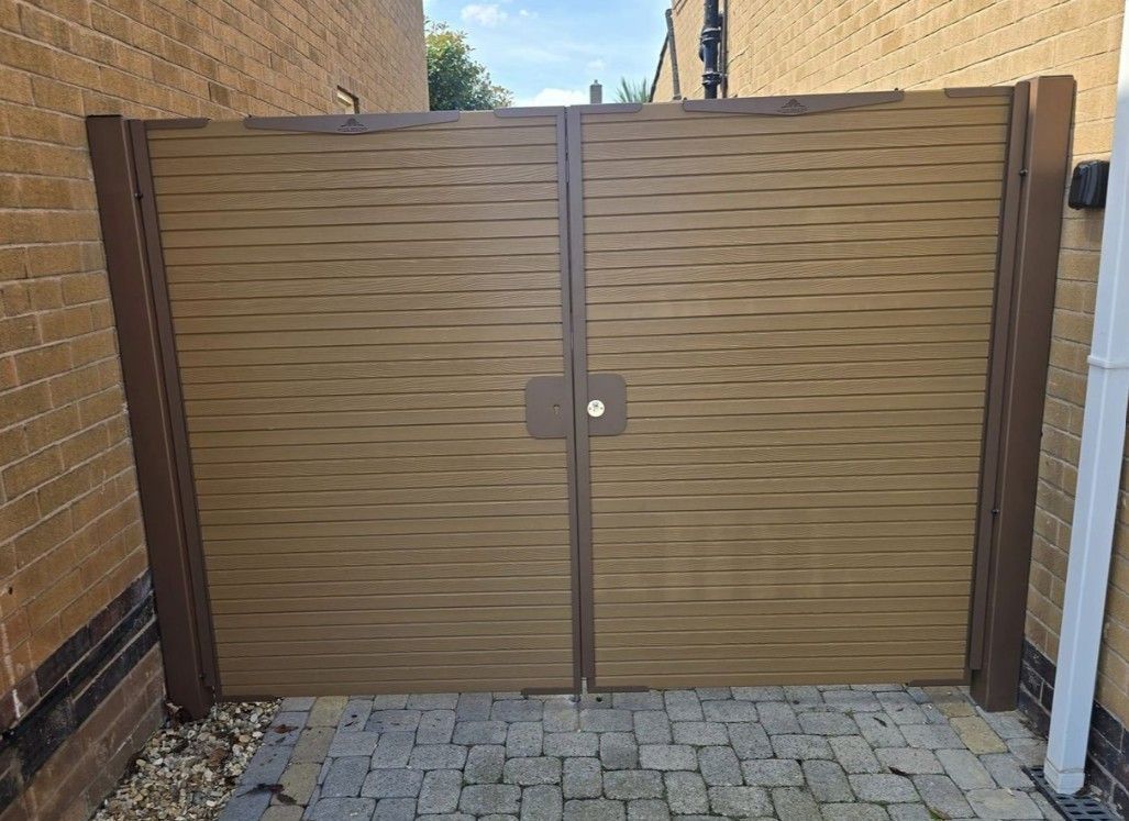 Composite Gates UK Natural Timber composite driveway gates with brown posts and frame fitted