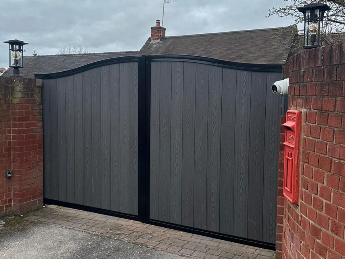 Hinged grey arched composite driveway gates in Abergavenny