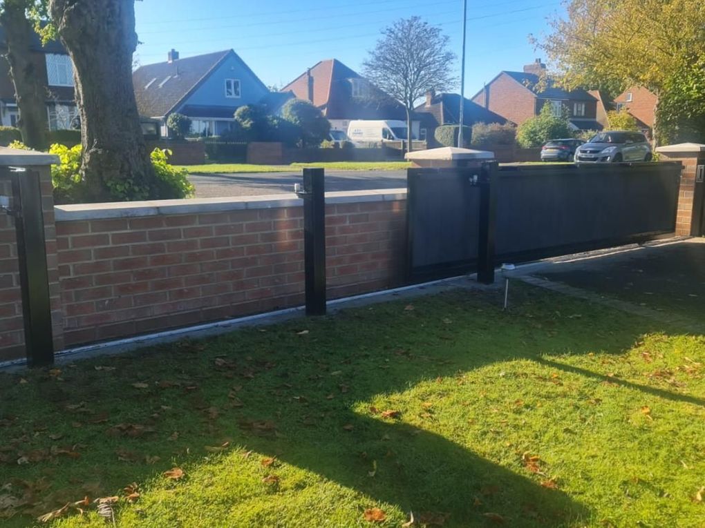 The same sliding composite gate seen from inside, showing the run alongside the boundary wall
