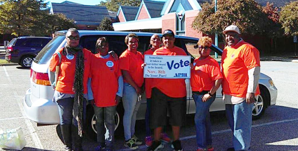 A group of people holding a sign that says vote