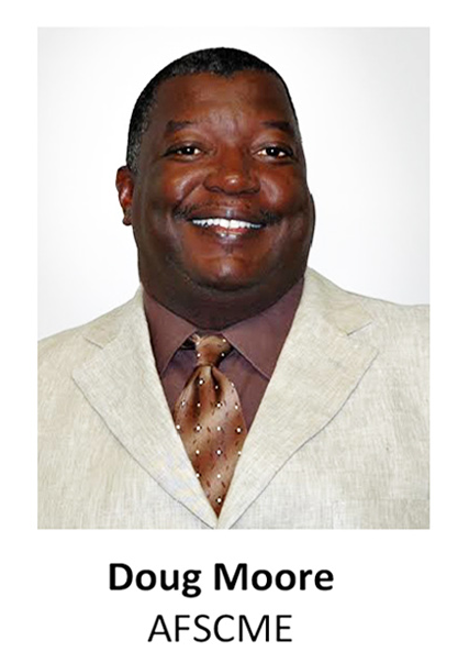 Portrait of Doug Moore in a light beige suit, brown shirt, and patterned tie, smiling on a white background
