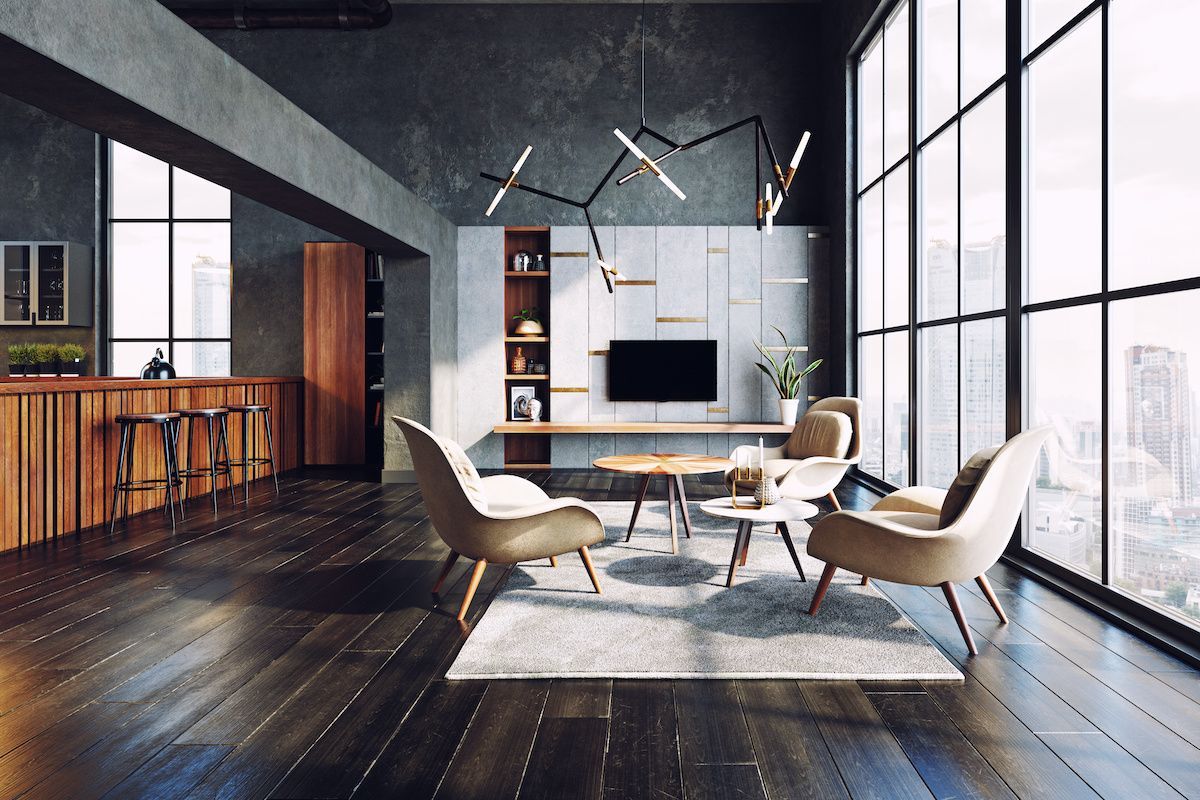 Modern luxury living room with dark interiors and large windows.