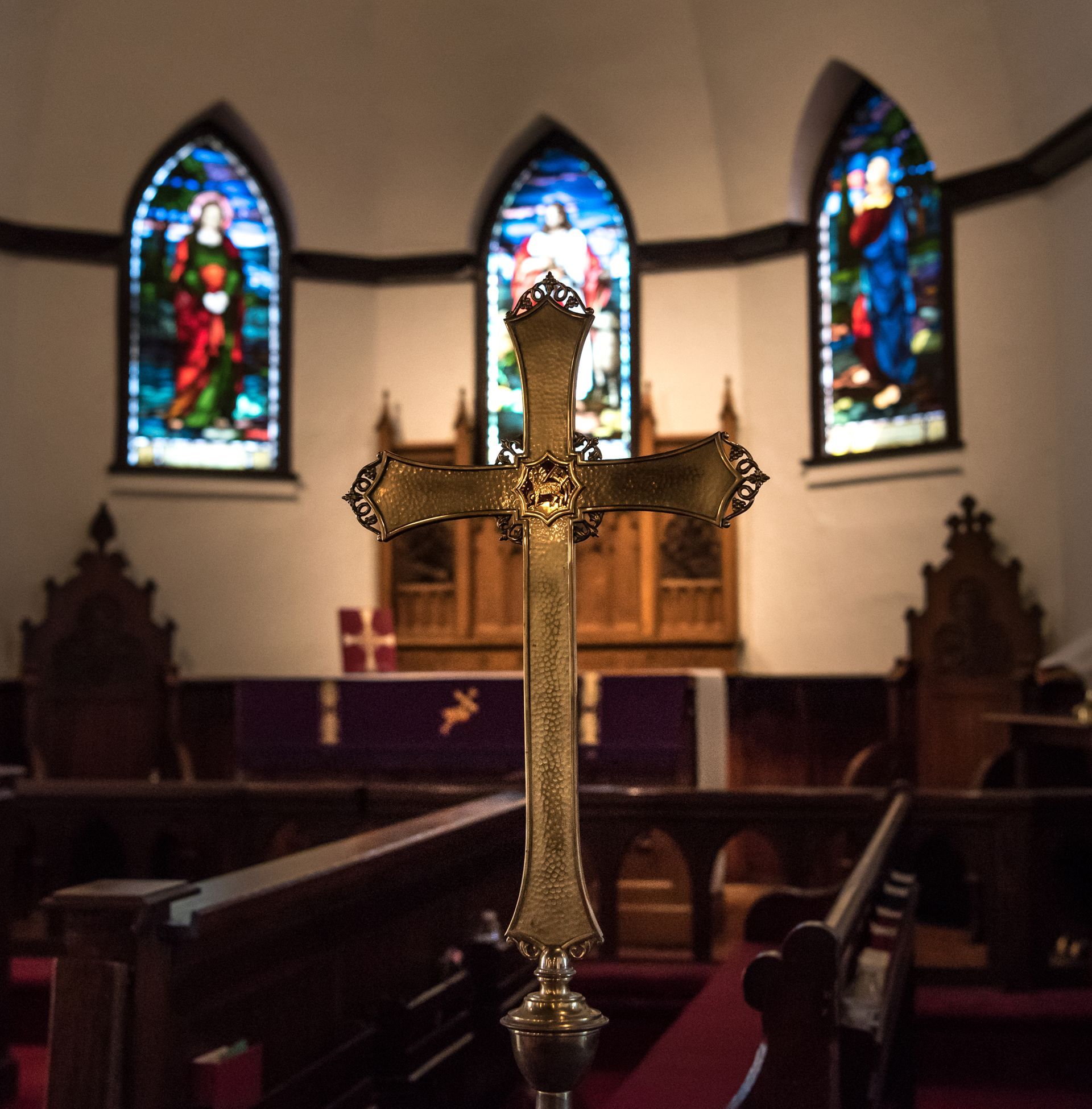 cross in focus in front of St. Johns altar