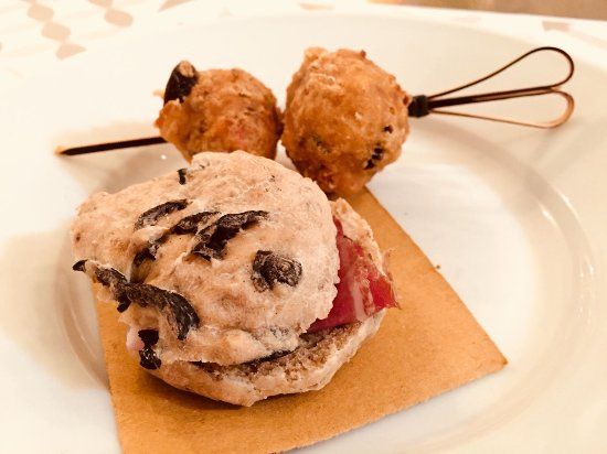 Piatto da dessert con tre pasticcini, tra cui un biscotto quadrato con gocce di cioccolato.