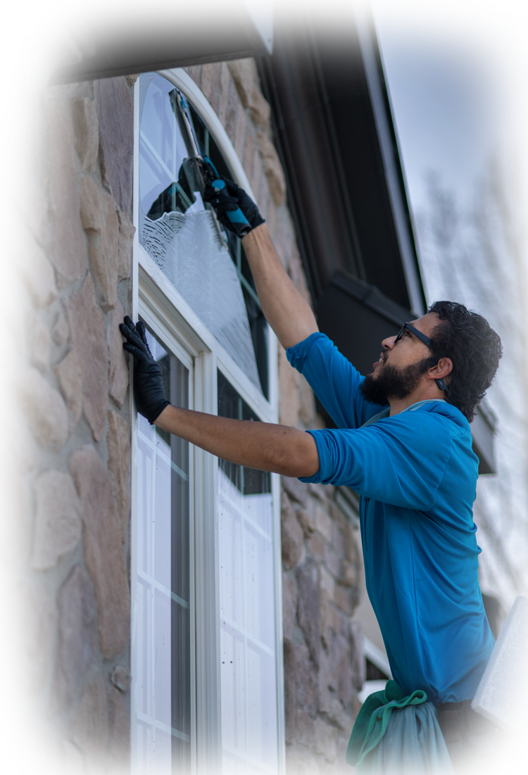 Window cleaner suspended on ropes, cleaning a building's exterior.