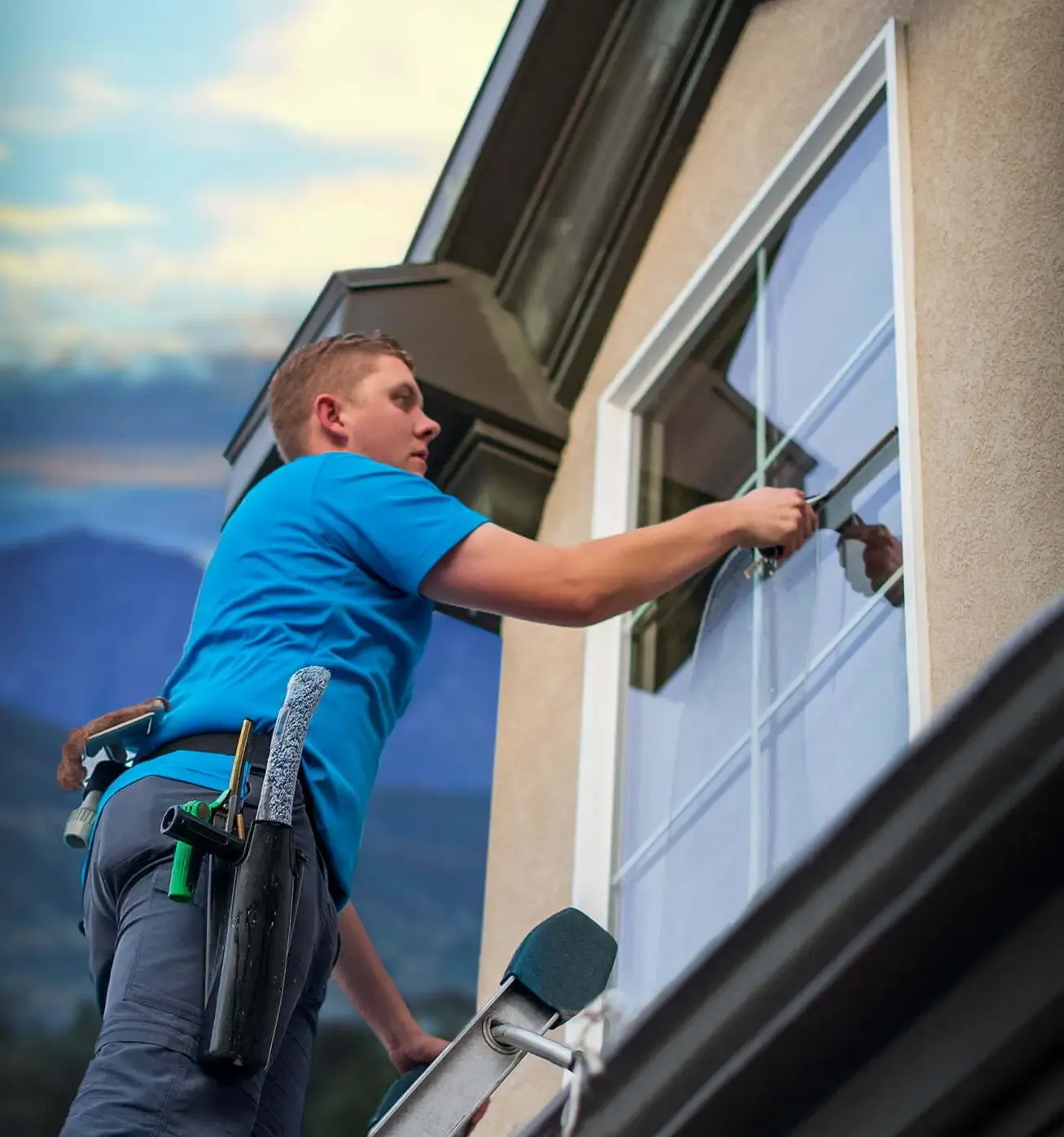 Person installing a window screen on a building.