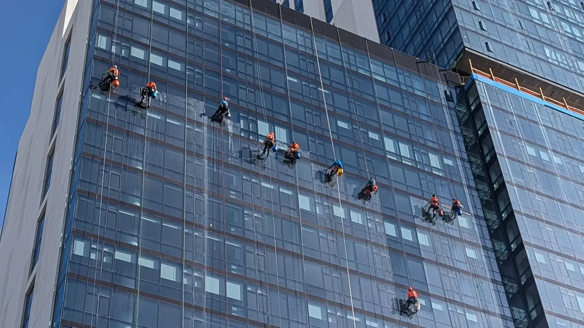 Window cleaner using a power washer on a house exterior