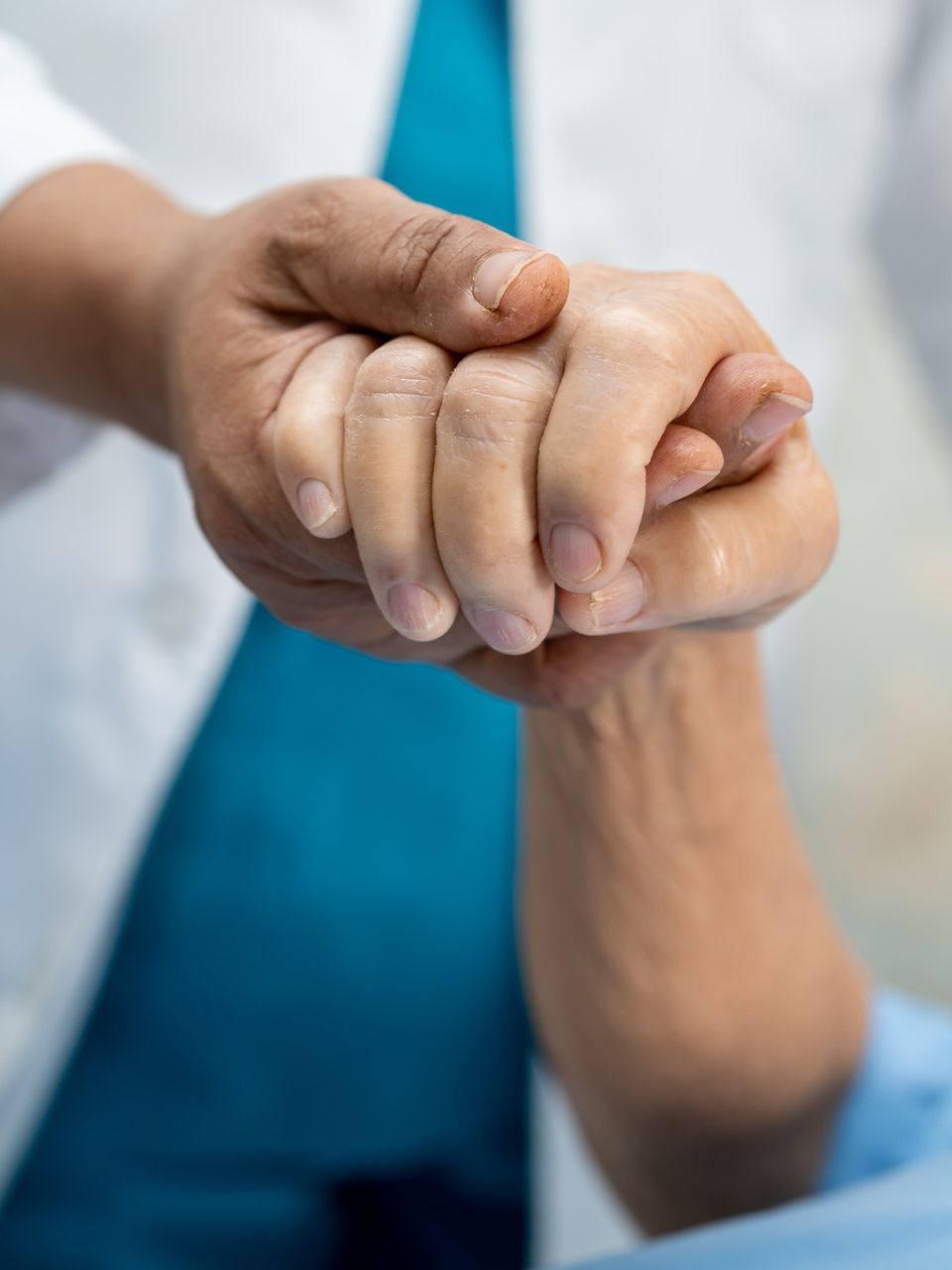 A doctor is holding the hand of a patient.