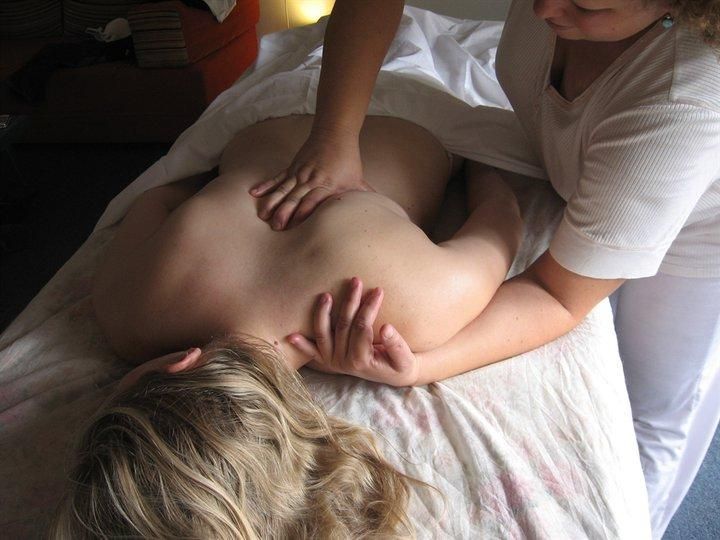 A back massage on a bed, with one person lying face down.