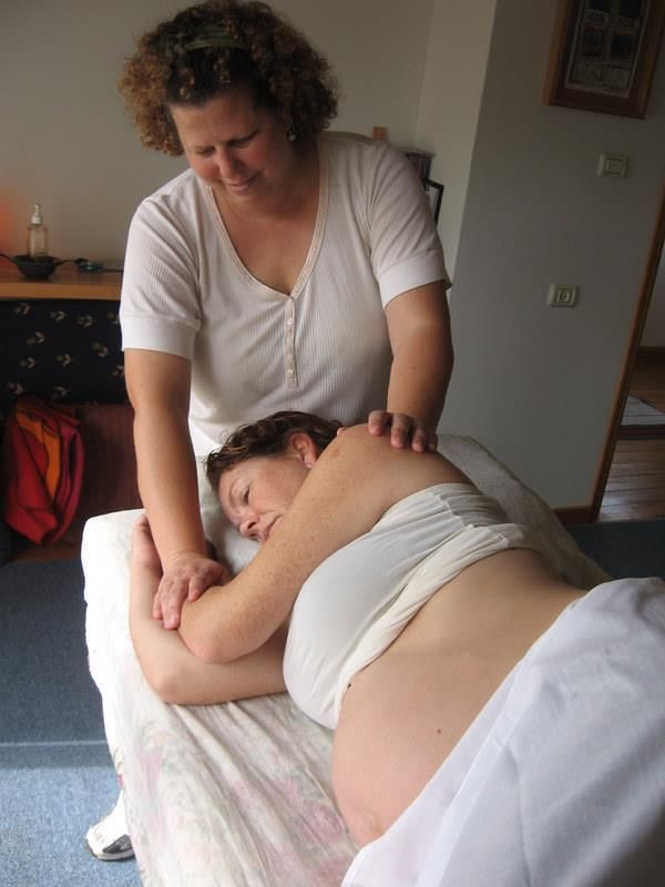 Woman receiving a back massage on a table in a home setting