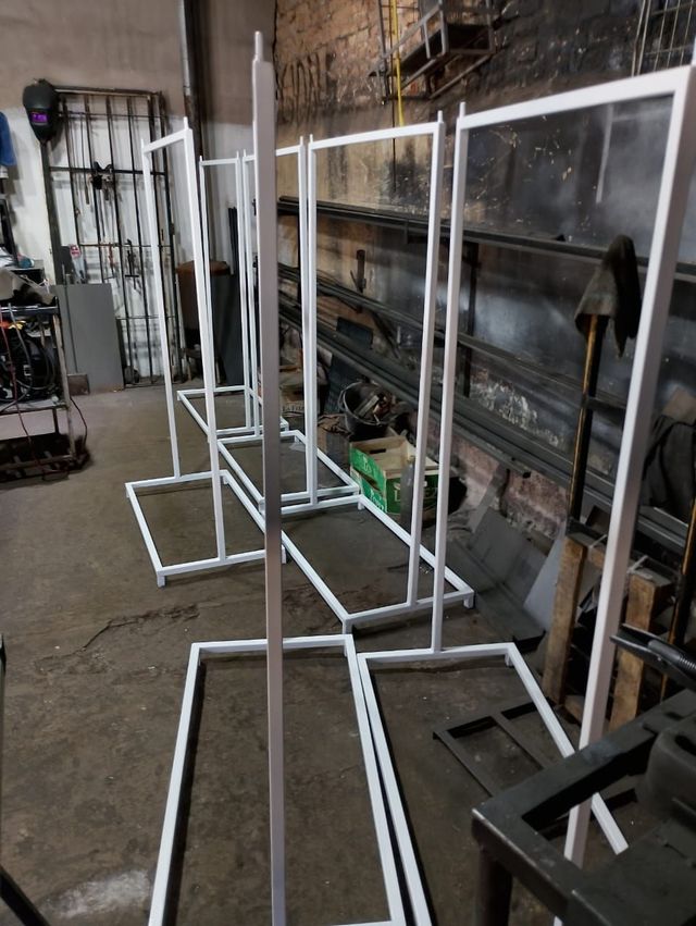 Taller con varios soportes de estructura metálica blanca alineados sobre un suelo de hormigón.