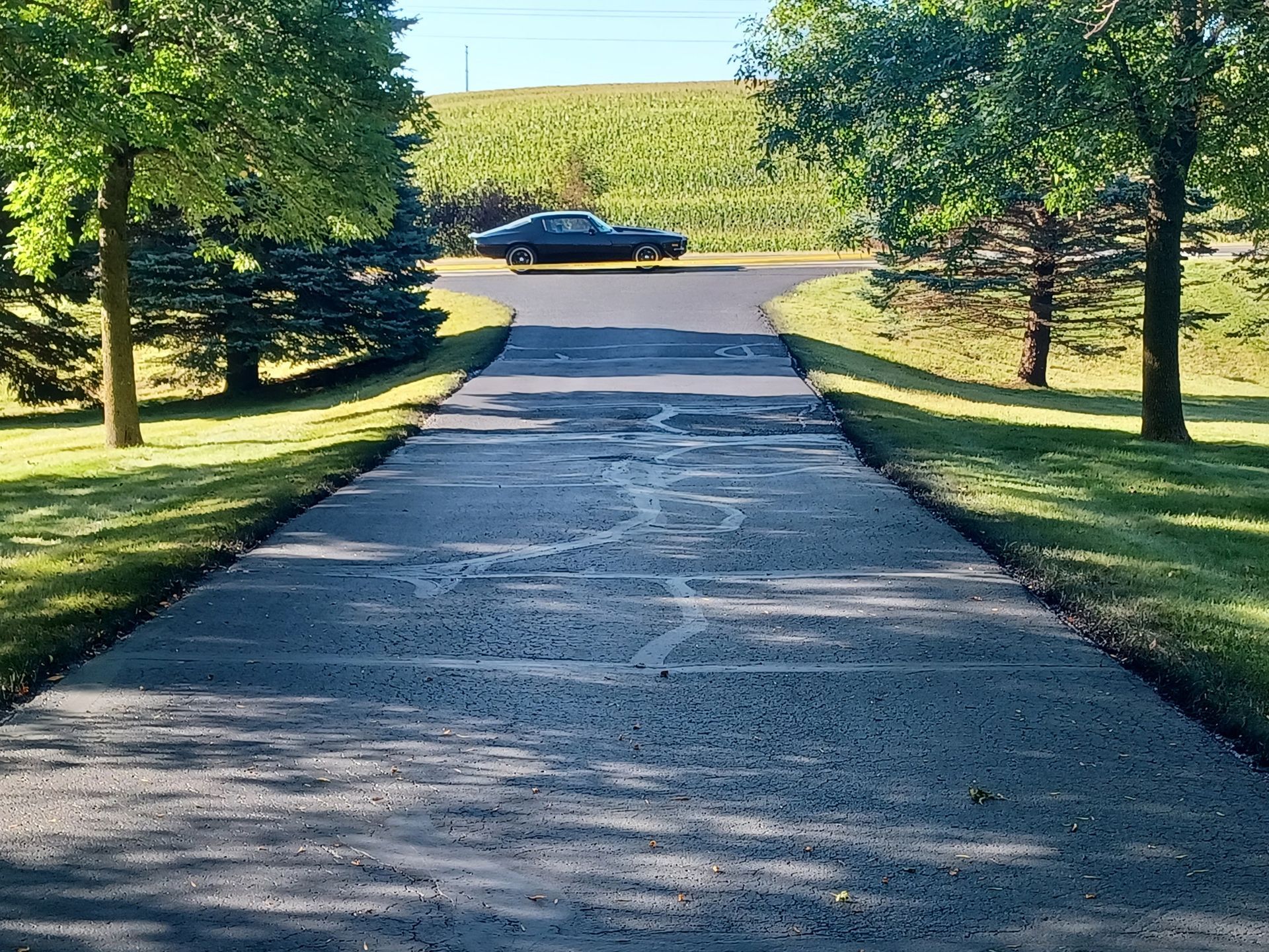 A black car is parked on the side of the road