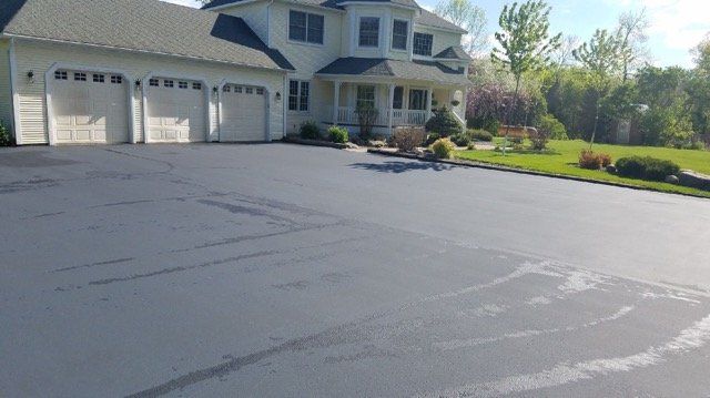 A large white house with a large driveway in front of it.