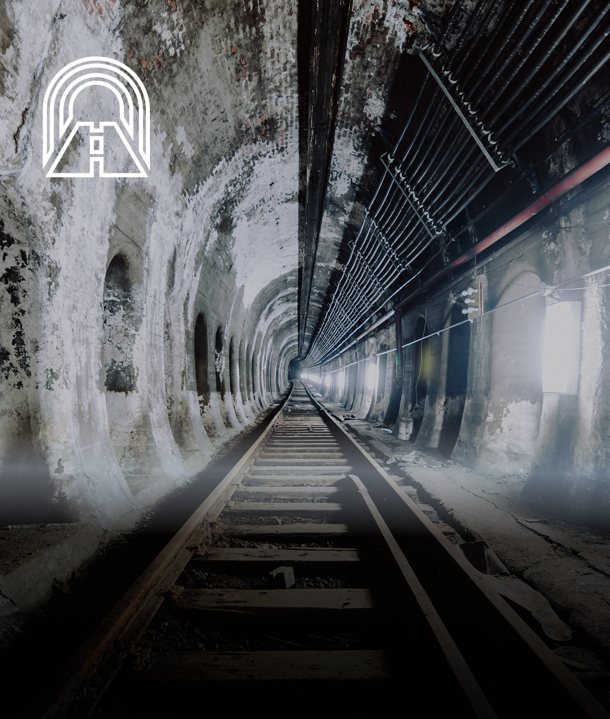 Tunnel with tracks disappearing into the distance. Bright glow over the opening, with tunnel icon in the corner.