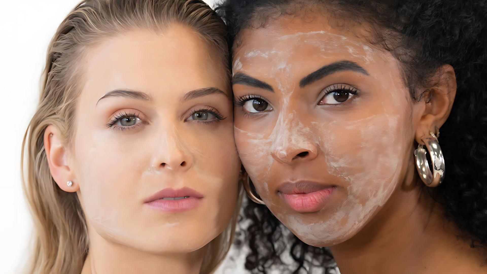 Two close-up faces side by side with neutral expressions, one wearing glittery makeup and hoop earrings