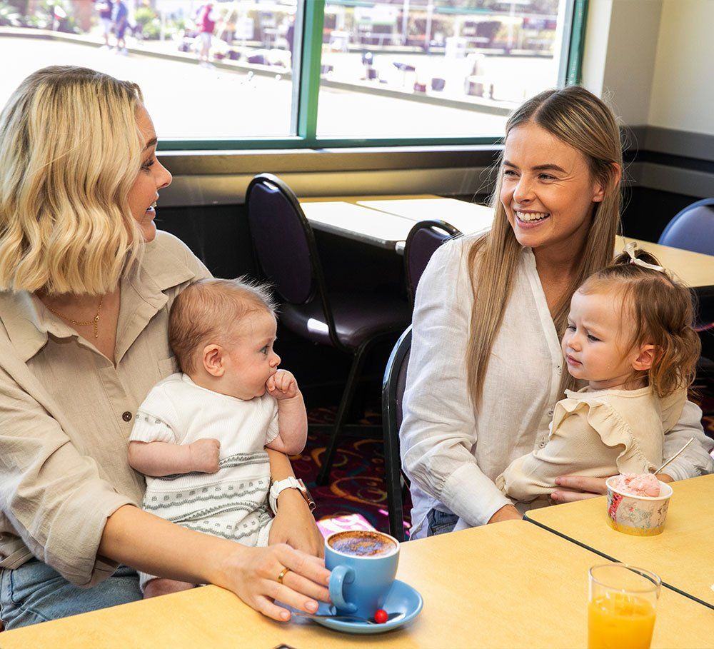 two mums and their adorable bubs