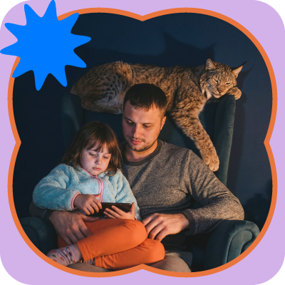 Man and child on a chair with a cat draped over the back, in a cozy dark room with a blue star graphic.