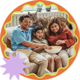 Streaming Family smiling on a couch with a cat, holding a bowl of popcorn, framed by a colorful scalloped border