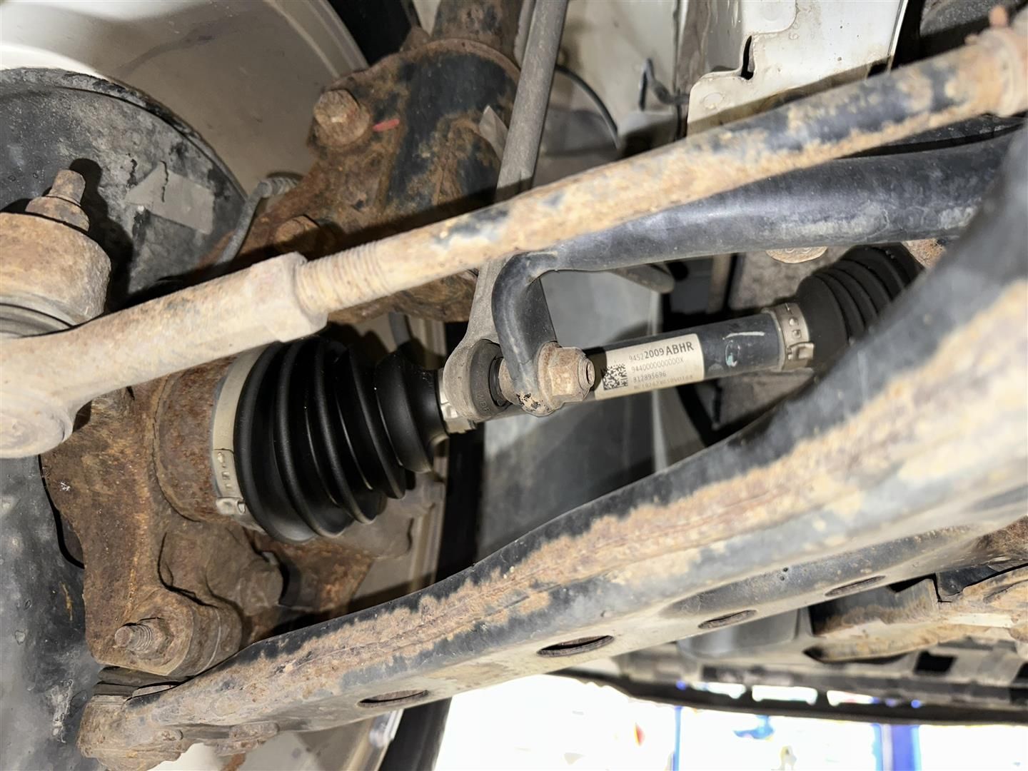 A close up of the underside of a car showing the drive shaft. | Lou's Car Care Center, Inc.