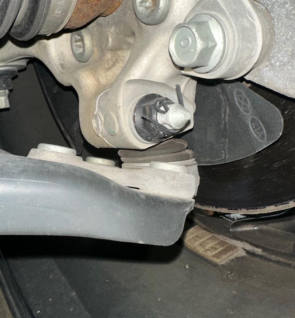 A close up of a car wheel with a nut on it | Lou's Car Care Center, Inc.