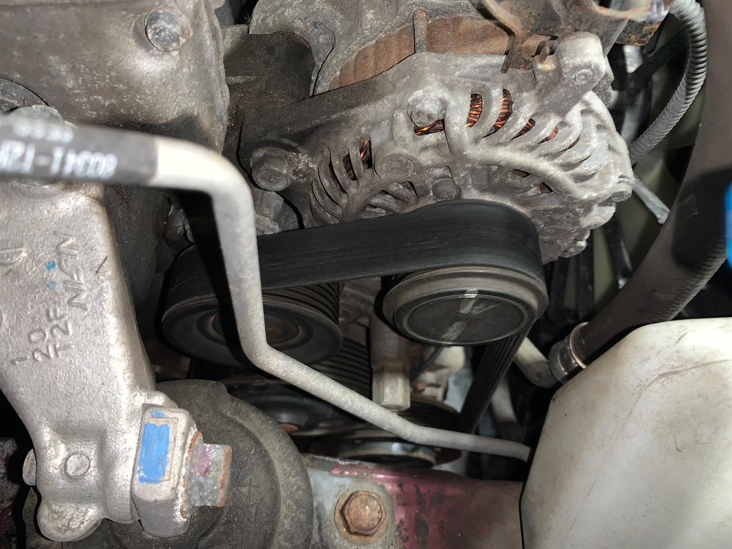 A close up of a belt on a car engine | Lou's Car Care Center Inc.