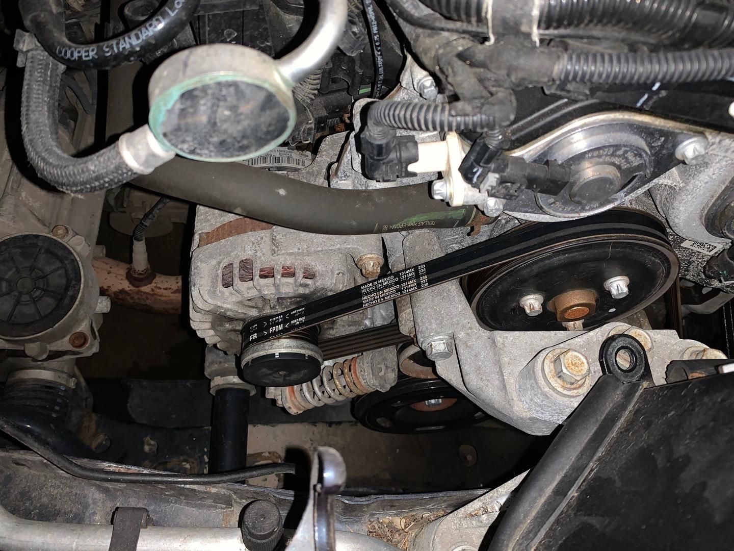 A close up of a belt on a car engine. | Lou's Car Care Center Inc.
