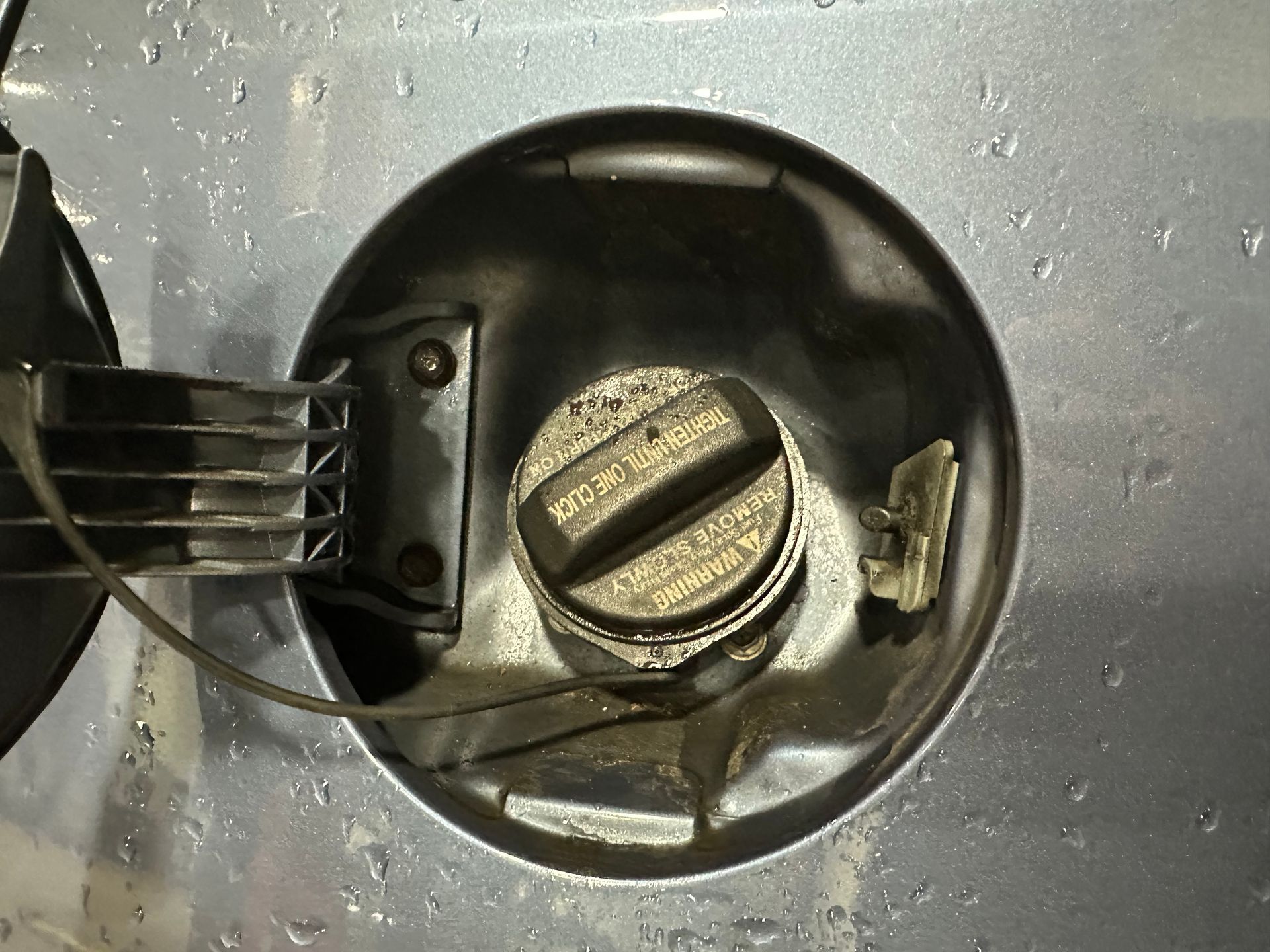 Black vehicle gas gap on silver car. | Lou's Car Care Center, Inc.