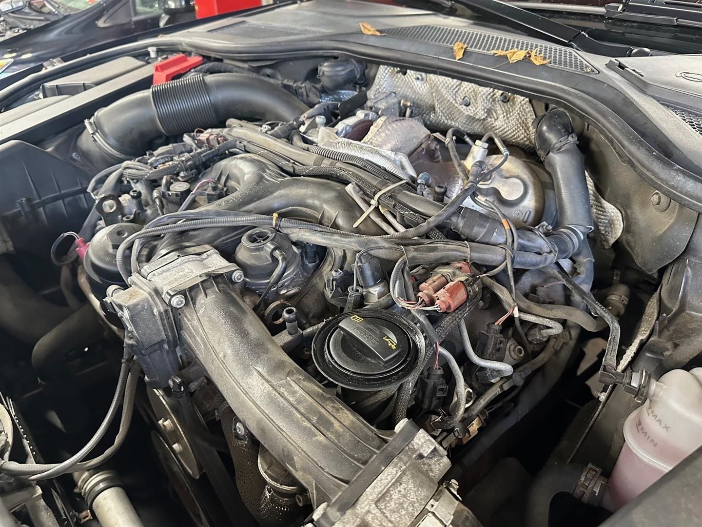A close up of a car engine with a lot of wires coming out of it. | Lou's Car Care Center, Inc.