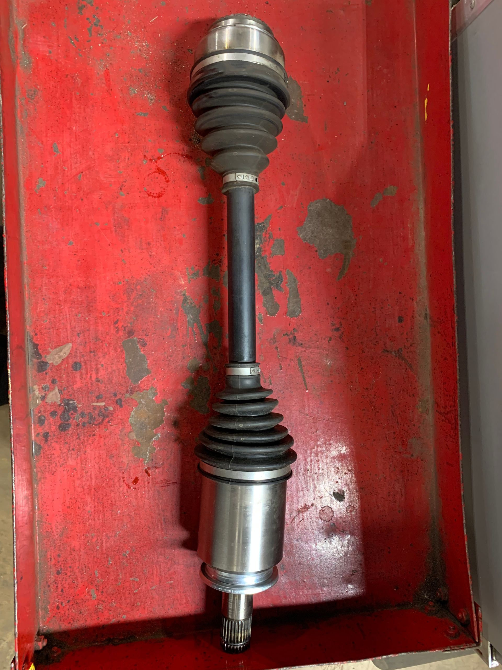A close up of a drive shaft on a white background | Lou's car care center