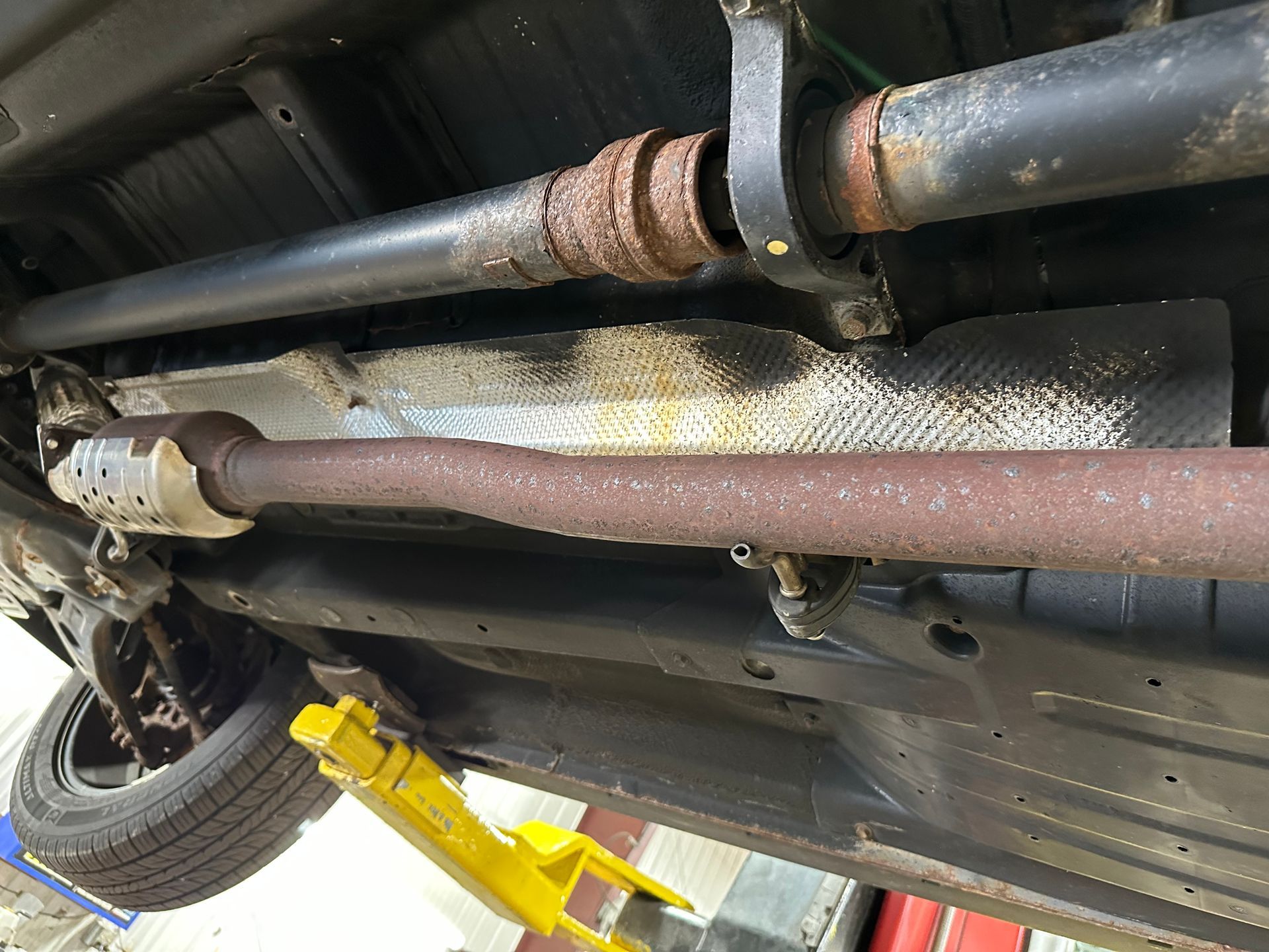 A close up of the underside of a car on a lift. | Lou's Car Care Center