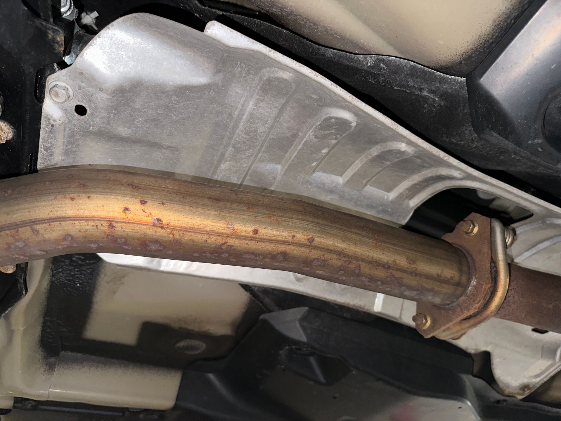 A close up of a rusty exhaust pipe on a car. | Lou's Car Care Center