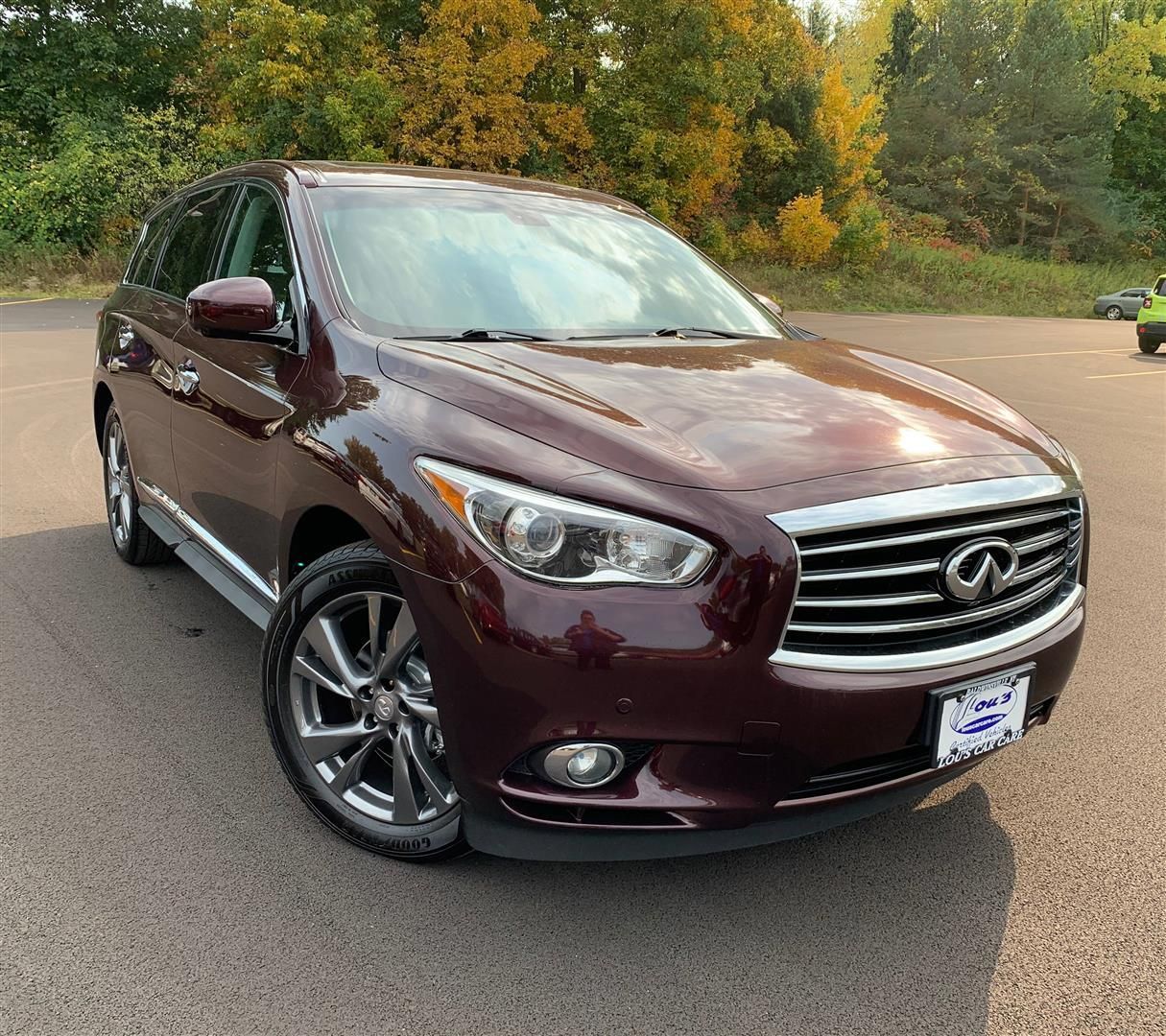 A red infiniti is parked in a parking lot. | Lou's Car Care Center, Inc.