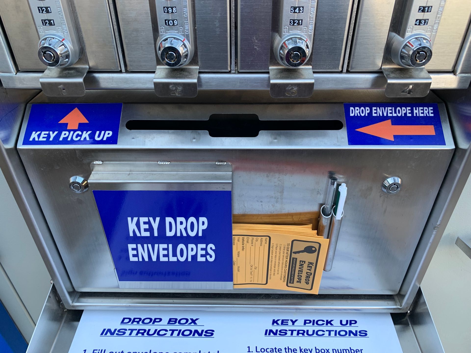 A key drop envelope box with a blue sign that says key drop envelopes | Lou's Car Care Center Inc.
