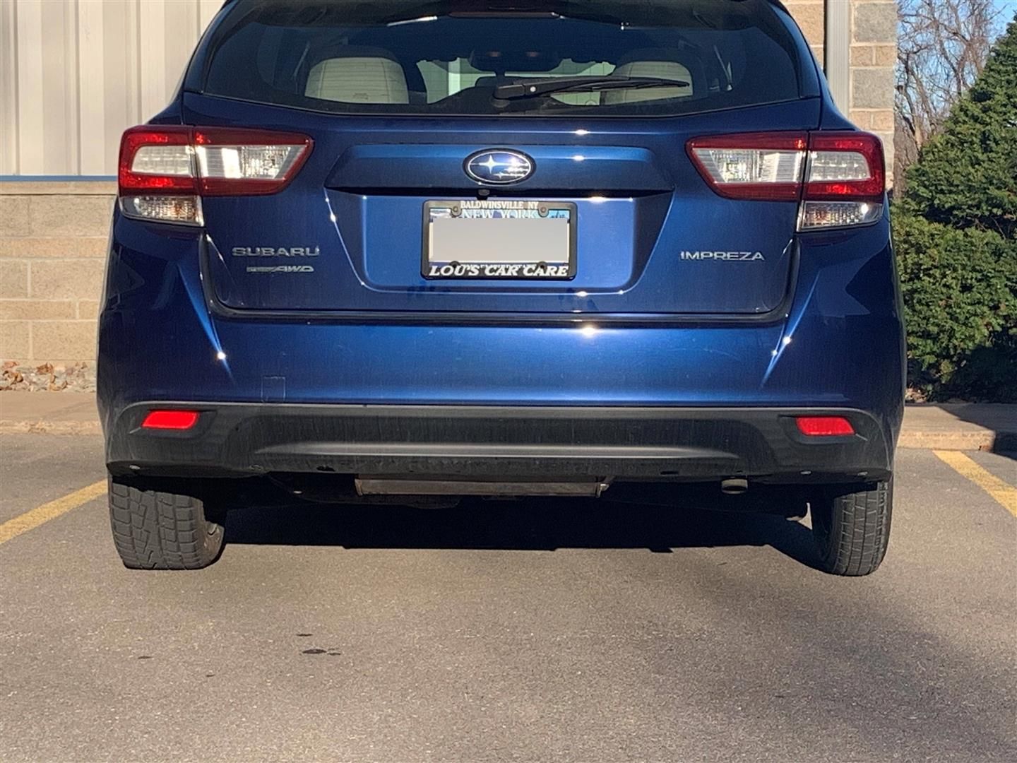 A blue subaru is parked in a parking lot | Lou's Car Care Center Inc.